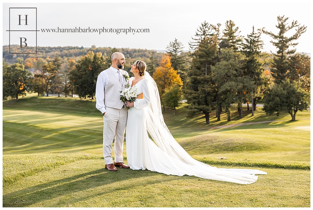 bride and groom pose on golf course at Belmont hills country club wedding