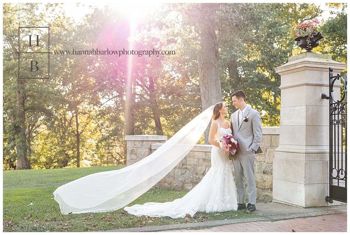 bride and groom embrace with light flare in background